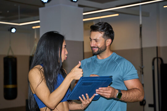 Fitness trainer discussing workout plan with client