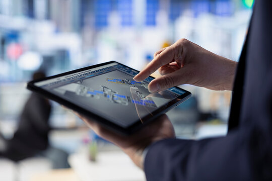 Solar panels plant employee analyzing performance data on tablet. Close up of photovoltaics factory engineer working on innovative solar cells design prototype using touchscreen device