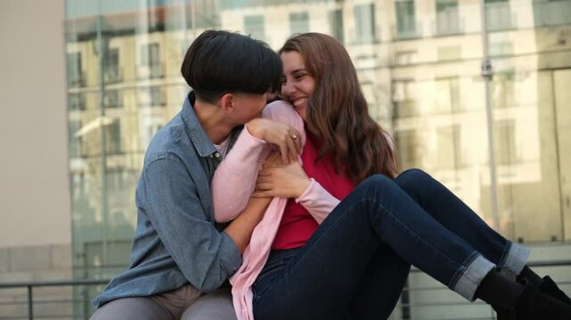 Romantic moments between two young women sharing laughter and affection in an urban setting