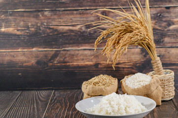 Fresh Rice Grains and Wheat Stalks on Rustic Wooden Background