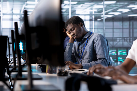 Bored data center engineer mindlessly using programming languages to construct algorithms and build applications. Fatigued server room employee tired of debugging and optimizing code
