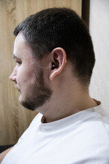 Obraz premium Close-up portrait of a young man who wears a hearing aid