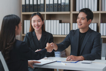 Business partners shaking hands at office desk during a meeting