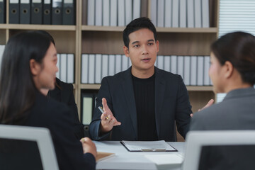 Asian businessman leading meeting with colleagues in office boardroom