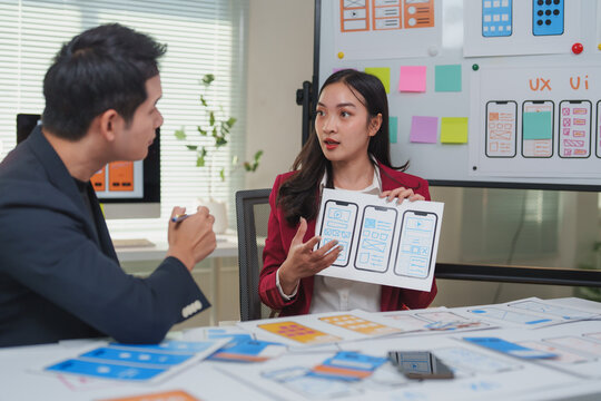 Ux ui designers discussing mobile app interface wireframe design