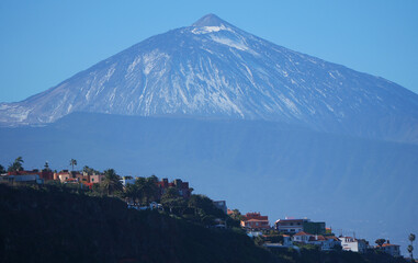 Blick auf den Teide Vulkan mit Schnee und Häusern im Vordergrund
