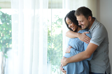 Black pregnant woman and husband looking at belly