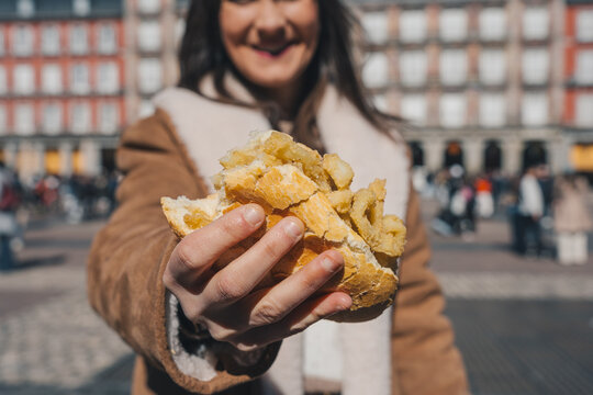 Tourist enjoying a bocadillo de calamares in plaza mayor, madrid