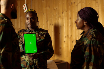 Soldiers at shooting gallery watching video on mockup tablet, participating in marksmanship training program. Military units looking at instructions on isolated screen device during shooting course