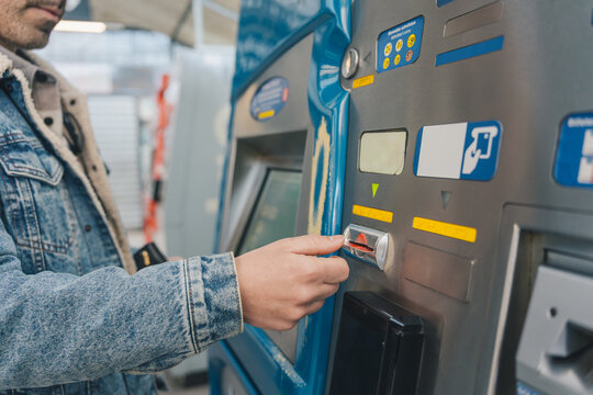 Man inserting ticket into automatic ticket validation machine