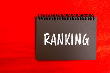 Ranking message written on black notebook page on red background. Conceptual ranking symbol. Copy...