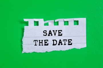 Save the date message written on ripped torn paper on green background. Conceptual save the date...