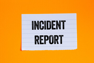 Incident report message written on ripped torn white paper piece on orange background. Conceptual incident report symbol. Copy space.