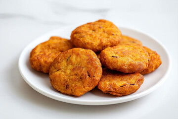 Delicious golden fritters served on a white plate, perfect for snacks or appetizers.