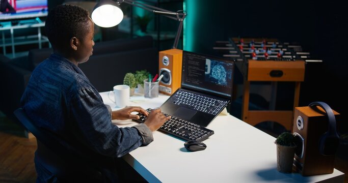 AI expert writes code on laptop in apartment office using Java programming languages. Artificial intelligence programmer remotely working on fixing database errors while working from home, camera B