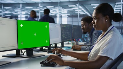 Software developer in server farm ensuring data remains shielded from potential threats using...