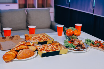 Happy young friends group having lunch at home. Asia family party eating pizza food and laughing enjoying meal while sitting at dining table together at house. Celebration holiday and togetherness.