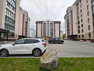 View of a multi-storey building to courtyard with a playground and parking for cars and other houses