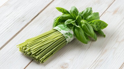 A clean package of spaghetti styled with a sprig of fresh basil on a light wooden table. pic