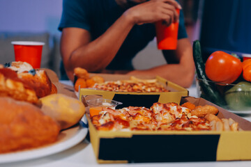Happy young friends group having lunch at home. Asia family party eating pizza food and laughing enjoying meal while sitting at dining table together at house. Celebration holiday and togetherness.