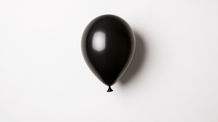 Obraz premium A solitary black balloon floating against a white background, symbolizing simplicity and elegance. isolated on white background.