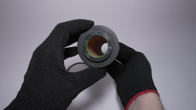 Hands Holding a Cylindrical Object with Protective Gloves for Safety