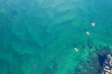 small fisihing boats fishing near the coast, aerial top view from a drone
