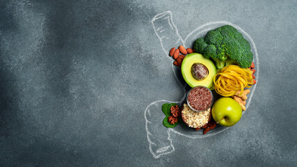 A set of fresh fruits, vegetables and nuts laid out in the shape of a stomach. A chalk drawing of a...