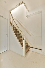 A well-lit and clean interior showcasing a beautiful curved staircase with white balusters and a...