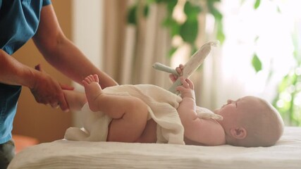 Massage legs feet for little child, infant baby performs upside-down stretching exercise under therapist guidance, enhancing body awareness and flexibility, 3 6 months, physical therapy, baby care
