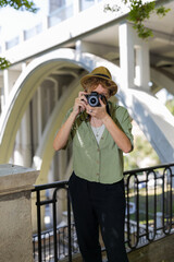 Woman photographer taking photos of a bridge in the city