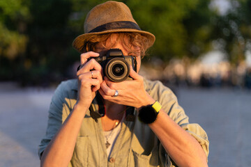 Photographer taking pictures outdoors with digital camera in nature