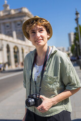Tourist holding camera exploring madrid city center near royal palace
