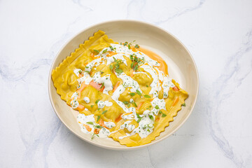 Ravioli with ricotta cheese and fresh herbs on a white background
