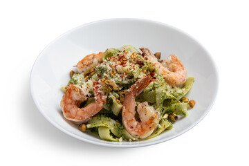 Spaghetti with shrimps and basil on a white plate.