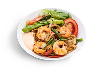 Spaghetti with shrimps and basil on a white plate.
