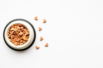 Bowl of biscuits for pets - food in a shape of heart, top view