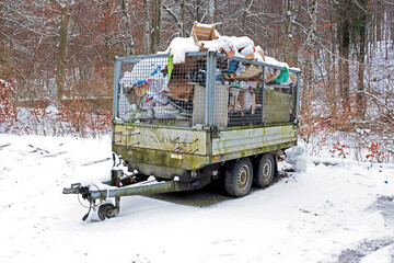environmental pollution, old car trailer full of garbage, parked in nature