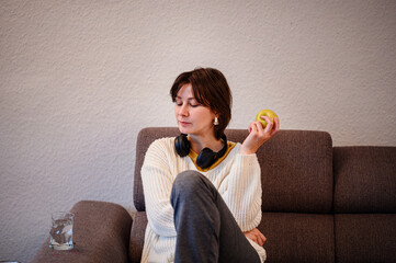 Woman Relaxing on Couch While Eating an Apple