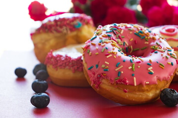 Glazed and decorated donuts in a box, showcasing a variety of flavors and toppings, with vibrant icing colors, set on a wooden table, perfect for a sweet treat or dessert