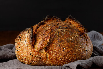 Crispy artisan sourdough bread with seeds on rustic wooden table