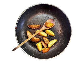 Overhead shot of roasted potato wedges in a dark frying pan with a wooden spoon. Rustic, warm, and inviting, perfect for food blogs, cookbooks, or restaurant menus.