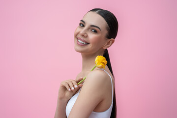 Waist up picture of a young woman with yellow flower in hand