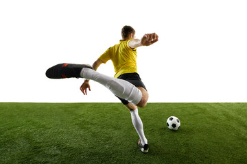 Low angle dynamic back view image of man, soccer player playing with intensity and focus, kicking...