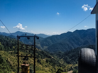 A magnificent and majestic mountain range soars high against the clear blue sky, while an old, solitary tire intriguing in nature adds an interesting perspective to this stunning landscape