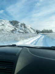 A car is steadily driving along a snowy road, navigating through the frostcovered landscape while...