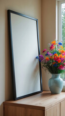 Bright and airy space with blank canvas on wooden table and a vase of wild flowers creating a natural vibe Interior design inspiration stock photo