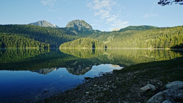 A serene mountain landscape with a reflective lake inviting exploration and adventure