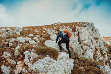 A male climber climbing up on the mountain rock cliff adventure travel adrenaline extreme sport outdoor.