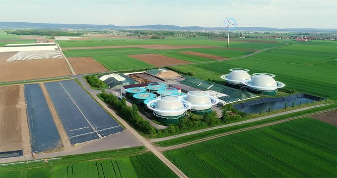 Concept of renewable energy from biomass. Biomass as bioenergy. Biomass power plant on agricultural fields, from above. Smart energy.